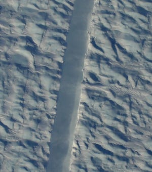 A preliminary image from NASA’s Digital Mapping Service shows the new rift in Greenland’s Petermann glacier, directly beneath the NASA Operation Icebridge aircraft. [GARY HOFFMANN/NASA DMS PHOTO VIA WASHINGTON POST]