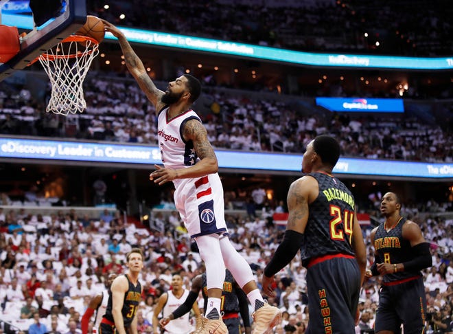 Washington Wizards forward Markieff Morris, left, dunks the ball while Atlanta Hawks forward Kent Bazemore, right, watches during the first half in Game 1 of a first-round NBA basketball playoff series, in Washington, Sunday, April 16, 2017. The Wizards won 114-107. (AP Photo/Manuel Balce Ceneta)
