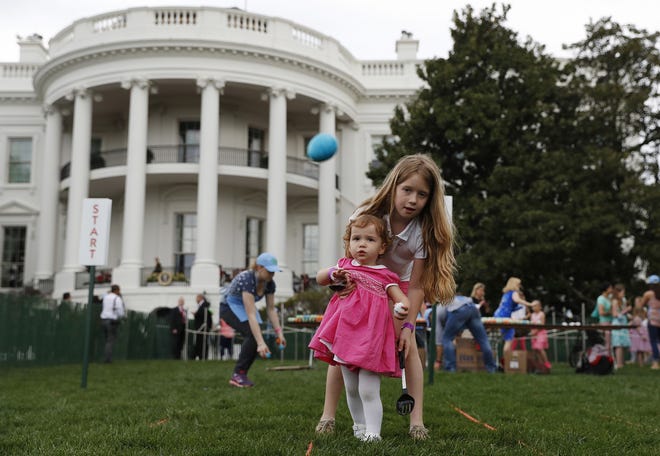 Eggs fly as Caroline Earnshaw, 10, helps her sister Brooke Earnshaw, 2, during the White House Easter Egg Roll on the South Lawn of the White House in Washington, Monday, April,17, 2017. President Donald Trump and first lady Melania Trump are set to host the official annual Easter egg roll at the White House.(AP Photo/Carolyn Kaster)