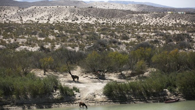 Horses and their riders sit on the Mexican side of the Rio Grande at the Boquillas Canyon Overlook inside Big Bend National Park in March.