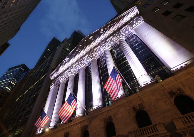 In this Oct. 8, 2014, file photo, American flags fly in front of the New York Stock Exchange. THE ASSOCIATED PRESS