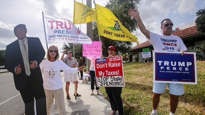 Trump supporters — including (from left to right) Anita Carbone, Paula Prudente, and Willy Guardiola — rallied in Palm Beach Gardens Tuesday, April 18, 2017. “Tea Party Patriots are doing it all over the country,” said Barbara Grossman (not pictured) of Palm Beach Gardens. “We are supporting President Trump’s desire for tax reform.” About two dozen people participated in the rally at PGA Boulevard’s intersection with Military Trail. (Bruce R. Bennett / The Palm Beach Post)