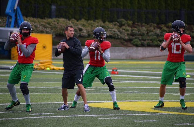 Oregon quarterback Travis Jonsen (11) throws during practice between quarterbacks Braxton Burmeister (17) and Justin Herbert (10) Monday, April 17, 2017. (Brian Davies/The Register-Guard)