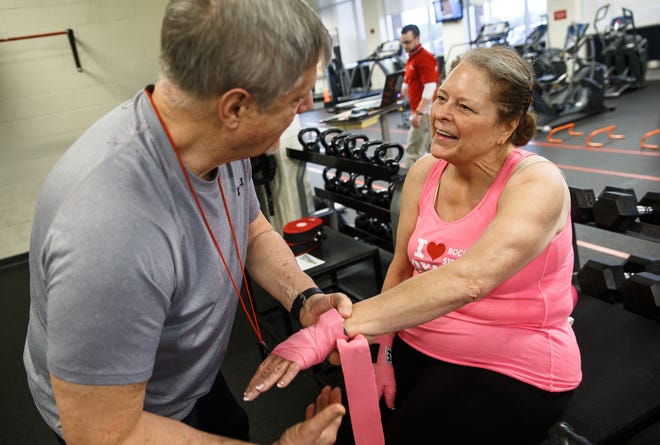 Lynn Kearney, right, gets help with her hand wraps from volunteer Alex Ferguson, left, in preparation for the Memorial Sportscare's Rock Steady Boxing program at the Kerasotes YMCA, Friday, April 14, 2017, in Springfield. [Justin L. Fowler/The State Journal-Register]