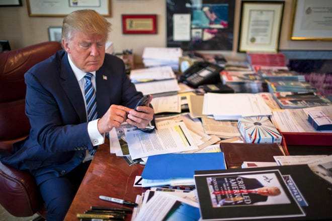 FILE PHOTO: Donald Trump demonstrates his tweeting skills in his office at Trump Tower in New York, Sept. 29, 2015.