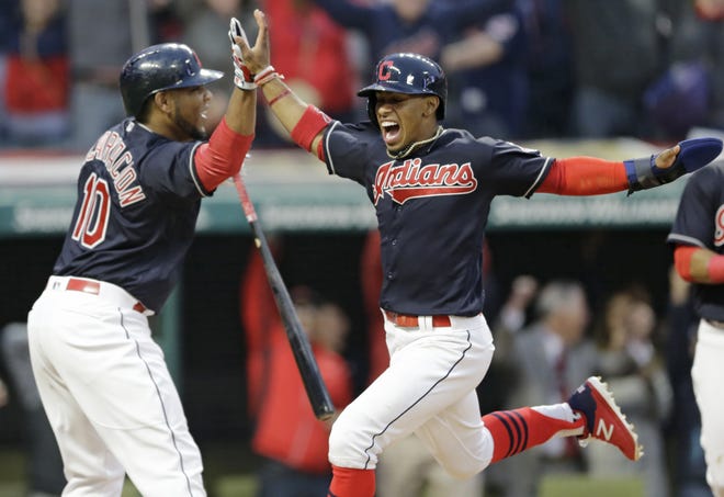 Cleveland's Francisco Lindor, right, scores the winning run in the 10th inning and is congratulated by Edwin Encarnacion on April 11 in Cleveland. [TONY DEJAK / AP]