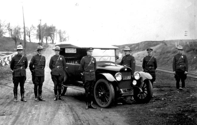 Troopers are pictured with a patrol vehicle in the Upper Peninsula, in this picture from 1922. [MSP PHOTO]