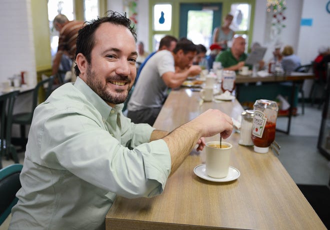 Wade Tatangelo seated at the counter of Coffee Carrousel in 2014. [Herald-Tribune archive]