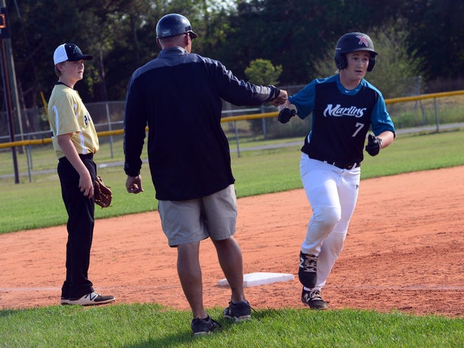 Destin's Preston Murphy gets a fist bump from Destin Coach Daniel Griffin after knocking his first of two home runs on Thursday against the Davidson Panthers. Murphy now leads the Marlins with eight homers on the season. [TINA HARBUCK/THE LOG]