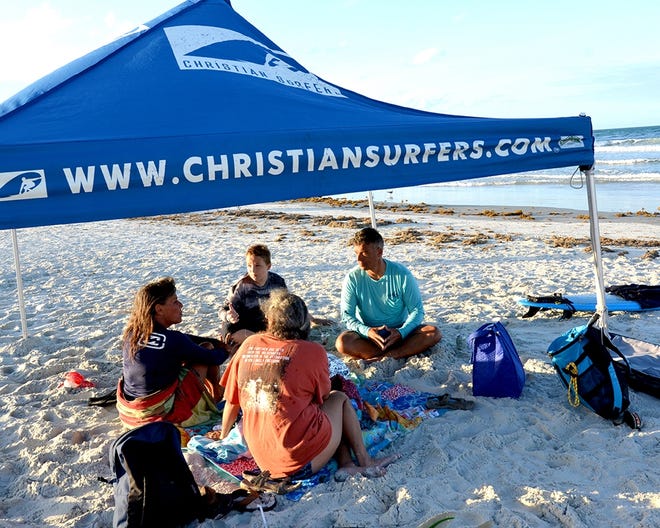 Surfing is accompanied by fellowship at meeting of the Christian Surfers of Daytona Beach, such as this one on a recent Tuesday near the Main Street Pier in Daytona Beach. [NEWS-JOURNAL/RIC BUSH]