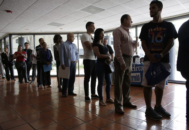 In this Tuesday, July 19, 2016, file photo, people stand in line to register for a job fair, in Miami Lakes, Fla. On Thursday, April 20, 2017, the Labor Department reported that more people sought U.S. unemployment benefits the week before, yet total applications remained at a historically low level that suggests workers are enjoying solid job security. (AP Photo/Lynne Sladky, File)