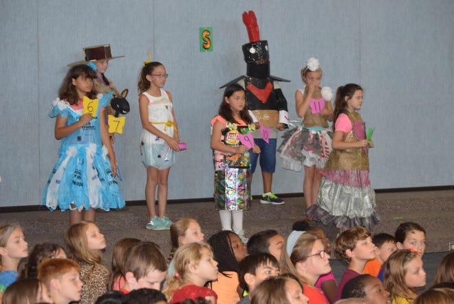 Student from Queens Creek Elementary showcase therir outfits made from recyclable materials in honor of Earth Day. The girl on the left, Mary Kellum-William, won first prize in the contest. [Alan Lane/The Daily News]