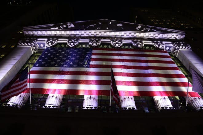 In this evening Friday, Feb. 17, 2017, photo, an American flag hangs on the front of the New York Stock Exchange. THE ASSOCIATED PRESS