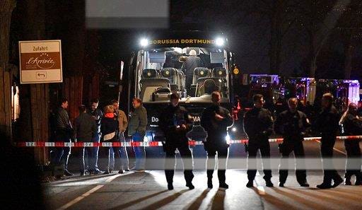 n this April 11 file photo police officers stand in front of Dortmund's damaged team bus after explosions which injured two people before the Champions League quarterfinal soccer match between Borussia Dortmund and AS Monaco in Dortmund, western Germany.