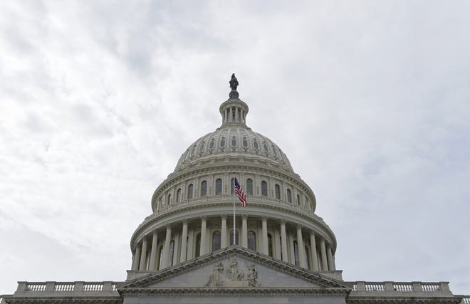 In this photo taken Feb. 28, 2017, a flag flies on Capitol Hill in Washington. Lawmakers return to Washington this week to a familiar quagmire on health care legislation and a budget deadline dramatized by the prospect of a protracted battle between President Donald Trump and congressional Democrats over his border wall. (AP Photo/Susan Walsh)