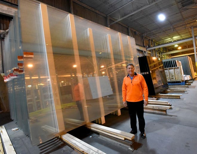 Monroe News photo by TOM HAWLEY Guardian Glass Plant Manager Gerry Hool stands in front of 11×17 jumbo size glass which has not been coated. Guardian Glass in Carleton wants to built a new facility with a new “jumbo coater” for advance glass coating operations for the jumbo size glass.