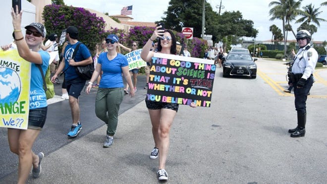 Police briefly stop traffic Saturday while hundreds of demonstrators in support of science participate in March for Science near Mar-a-Lago in Palm Beach. (Meghan McCarthy / Daily News)