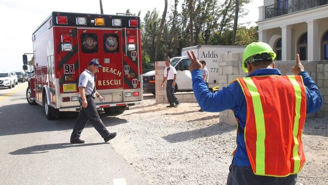 Julio Salcedo sends off his co-worker as Palm Beach Fire-Rescue takes him to St. Mary’s Medical Center. The unidentified co-worker fell about 20 feet down an elevator shaft, according to Fire-Rescue officials. (Carla Trivino / Daily News)