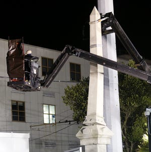 Workers dismantle the Liberty Place monument Monday, April 24, 2017, which commemorates whites who tried to topple a biracial post-Civil War government, in New Orleans. It was removed overnight in an attempt to avoid disruption from supporters who want the monuments to stay. THE ASSOCIATED PRESS