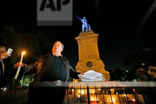 Charles Lincoln speaks during a candlelight vigil at the statue of Jefferson Davis in New Orleans, Monday. New Orleans will begin taking down Confederate statutes, becoming the latest Southern body to divorce itself from what some say are symbols of racism and intolerance.