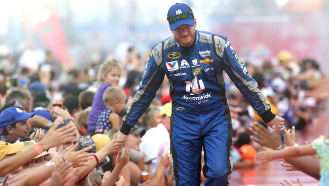 Dale Earnhardt Jr., gets low fives during driver introductions at the Coke Zero 400 at Daytona International Speedway on July 2 in Daytona Beach, Fla. (TNS via Associated Press)