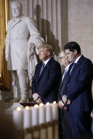 President Donald Trump, accompanied by U.S. Holocaust Memorial Council Chairman Tom Bernstein, center, and Israeli Ambassador to the U.S. Ron Dermer, participates in the United States Holocaust Memorial Museum's National Days of Remembrance ceremony on Capitol Hill in Washington, Tuesday, April 25, 2017. THE ASSSOCIATED PRESS