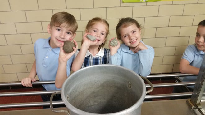Immaculate Conception School first-graders recently performed a study on fairytales. Pictured: students Lukas Kelley, Olivia Colman and Ellie Stull prepare to make a replica stone soup. PHOTO PROVIDED