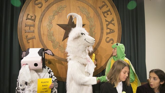 Raj Mankad, middle, dressed as a goat, introduces himself to Kristina Flakowitz, dressed as a sea turtle, at a news conference at the Capitol on Tuesday April 25, 2017, to show their support for plastic bag bans. JAY JANNER / AMERICAN-STATESMAN