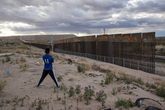 FILE - In this March 29, 2017, file photo, a youth looks at a new, taller fence being built along U.S.-Mexico border, replacing the shorter, gray metal fence in front of it, in the Anapra neighborhood of Ciudad Juarez, Mexico, across the border from Sunland Park, New Mexico. Most Americans oppose funding President Donald Trump's wall along the U.S.-Mexico border. ThatþÄö‡Ñ‡¥s according to a poll released Thursday by The Associated Press-NORC Center for Public Affairs Research. (AP Photo/Rodrigo Abd, File)