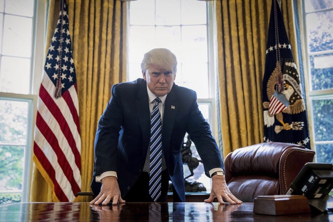 President Donald Trump poses for a portrait in the Oval Office in Washington on Friday. Trump is preparing to mark the end of his first 100 days in office. [ANDREW HARNIK/THE ASSOCIATED PRESS]