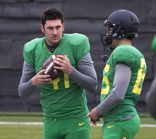 Oregon kicker Aidan Schneider (left) and long snapper Devin Melendez await the call for a punning drill on the sidelines during Spring Football Camp. (Chris Pietsch/The Register-Guard)