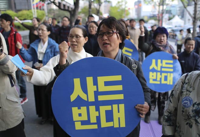 South Korean shout slogans during a rally to oppose a plan to deploy the advanced U.S. missile defense system called Terminal High-Altitude Area Defense, or THAAD, near U.S. Embassy in Seoul, South Korea, Wednesday, April 26, 2017. Hours after a display of North Korean military power, rival South Korea announced Wednesday the installation of key parts of a contentious U.S. missile defense system meant to counter the North. The letters read "Oppose THAAD." THE ASSOCIATED PRESS