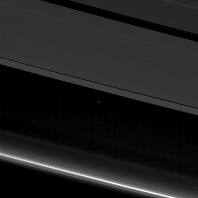 This April 12, 2017, image provided by NASA shows planet Earth and the moon, center left, as small points of light behind the rings of Saturn, captured by the Cassini spacecraft, 870 million miles (1.4 billion kilometers) away from Earth. Launched in 1997, Cassini reached Saturn in 2004 and has been exploring it from orbit ever since. Cassini's fuel tank is almost empty, so NASA has opted for a risky, but science-rich grand finale. NASA/THE ASSOCIATED PRESS