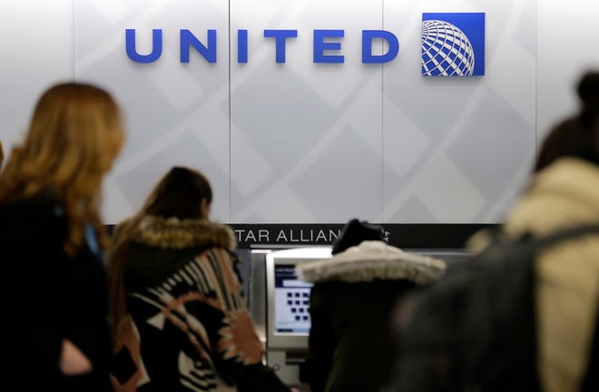In this Wednesday, March 15, 2017, photo, people stand in line at a United Airlines counter at LaGuardia Airport in New York. In a report being issued Thursday, April 27, 2017, about the April 9 dragging incident involving a passenger on an overcrowded United Express plane, United spelled out how it selects passengers for involuntary bumping. THE ASSOCIATED PRESS