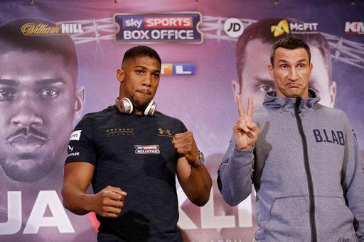 British boxer Anthony Joshua, left, and Ukrainian boxer Wladimir Klitschko pose for the media at the end of a press conference at Sky studios in west London, Thursday, April 27, 2017. They are due to fight for the IBF heavyweight world title on Saturday at Wembley stadium in London. (AP Photo/Matt Dunham)