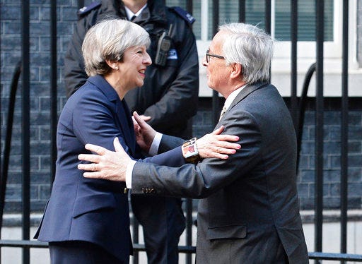 Britain's Prime Minister Theresa May, left, greets European Commission President Jean-Claude Juncker ahead of a working dinner at 10 Downing Street, London, Wednesday, April 26, 2017. (John Stillwell/PA via AP)