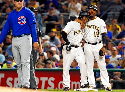 Pittsburgh Pirates' Gift Ngoepe, a native of South Africa, and the first baseball player from the continent of Africa to play in the Major Leagues, second from right, celebrates with first base coach Kimera Bartee (18) after getting a single off Chicago Cubs starting pitcher Jon Lester in his first Major League at-bat in the fourth inning of a baseball game in Pittsburgh, Wednesday, April 26, 2017. (AP Photo/Gene J. Puskar)