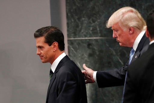 FILE - In this Aug. 31, 2016 file photo, Republican presidential nominee Donald Trump walks with Mexico President Enrique Pena Nieto at the end of their joint statement at Los Pinos, the presidential official residence, in Mexico City. Like the rest of the world, Mexico only learned through media reports on Wednesday, April 26, 2017 that the Donald Trump Administration was considering a draft executive order to withdraw the United States from the North American Free Trade Agreement. (AP Photo/Dario Lopez-Mills, File)
