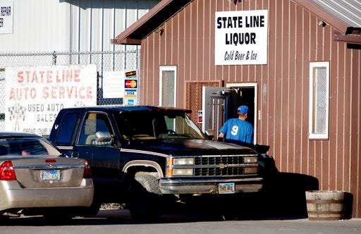 FILE - In this Oct. 21, 2016, file photo, a customer enters State Line Liquor, one of four beer stores in the town of Whiteclay, Neb. Owners of the four beer stores that sell millions of cans of beer each year near a South Dakota American Indian reservation that is plagued by alcohol-related problems, are appealing a state regulator's decision not to renew their liquor licenses. The appeal was filed late Monday, April 24, 2017, in Lancaster County District Court. (Francis Gardler/The Journal-Star via AP, File)/The Journal-Star via AP)