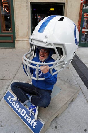 Richard Burse poses inside an Indianapolis Colts helmet before going into the NFL football team's draft party Thursday, April 27, 2017, in Indianapolis. (AP Photo/Darron Cummings)
