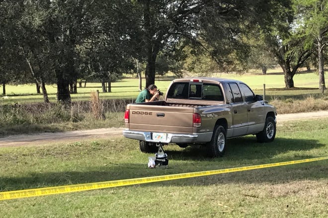 Marion County Sheriff's Office evidence technician Sue Livoti photographs a pickup truck at the scene of a shooting in the Weirsdale area on Feb. 24. [Austin L. Miller/Star-Banner/File]