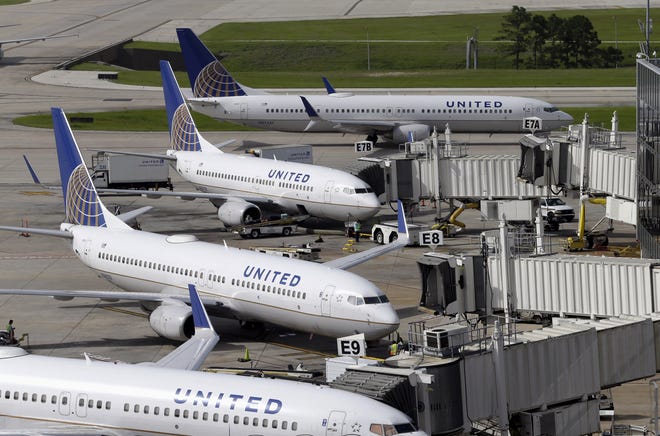 In this July 8, 2015, file photo, United Airlines planes are parked at their gates as another plane, top, taxis past them at George Bush Intercontinental Airport in Houston. The airline has reached a settlement with the Kentucky doctor that was forcibly removed from a flight in Chicago.