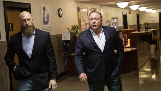 Alex Jones, right, is shown arriving at the Travis County Courthouse in downtown Austin on the first day of the trial. Tamir Kalifa / AMERICAN-STATESMAN)