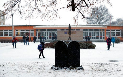 In this picture taken on Tuesday, Jan. 31, 2017, children walk to school past a memorial to a former Jewish cemetery in Prostejov, Czech Republic. A Jewish foundation said Friday, April 28, 2017 it discovered this week that the tombstone of Prostejov Rabbi Zvi Horowitz, who died in 1816 was broken into two pieces. (AP Photo/Petr David Josek)