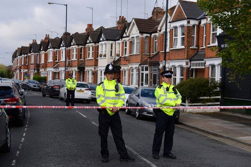Police officers man the cordoned off area in London's Harlesden Road Friday, April 28, 2017, after British counter-terror police have shot a woman and arrested several people in raids in London and southeastern England. The injured suspect has been hospitalized in serious condition after the raid in northwest London. (Stefan Rousseau/PA via AP)