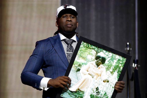 UCLA's Takkarist McKinley carries a photograph of his grandmother onstage after being selected by the Atlanta Falcons during the first round of the 2017 NFL football draft, Thursday, April 27, 2017, in Philadelphia. (AP Photo/Matt Rourke)