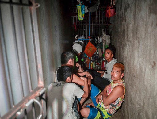 In this Thursday, April 27, 2017 photo, detainees crouch on the floor inside a secret jail after being discovered by the Commission on Human Rights at Police Station 1 at Tondo district in Manila, Philippines. Philippine police relieved a station chief and his staff on Friday after human rights representatives discovered the secret jail cell inside the Manila station where a dozen detainees complained they were being held for extortion. (AP Photo/Ezra Acayan)