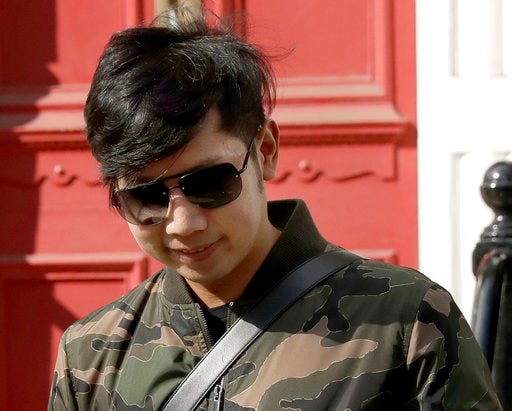 FILE - In this Wednesday, April 5, 2017, file photo, Vorayuth "Boss" Yoovidhya, whose grandfather co-founded energy drink company Red Bull, walks to get in a car as he leaves a house in London. Police in Thailand say they have begun the process of requesting an arrest warrant for the heir to the Red Bull energy drink fortune accused of a deadly hit-and-run accident almost five years ago but never charged. National police chief Chaktip Chaijinda announced that the effort to arrest Vorayuth began Friday, April 28, in Bangkok. (AP Photo/Matt Dunham, File)