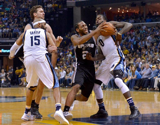 San Antonio Spurs forward Kawhi Leonard (2) drives against Memphis Grizzlies forward JaMychal Green (0) as Grizzlies guard Vince Carter (15) and Spurs center Pau Gasol, back left, move for position during the second half of Game 6 in an NBA basketball first-round playoff series Thursday, April 27, 2017, in Memphis, Tenn. (AP Photo/Brandon Dill)