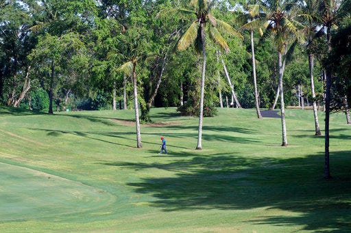 In this April 13, 2017, photo, a player walks on the golf course at Nirwana Bali Resort which will be upgraded to a six-star resort managed by Trump Organization, in Beraban, Bali, Indonesia. Plans for a Trump hotel golf course overlooking a sacred Hindu temple that juts into the Indian Ocean are being reshaped by locals, who welcome new investment in the popular Indonesian resort island but are also determined to preserve their unique traditions. (AP Photo/Firdia Lisnawati)